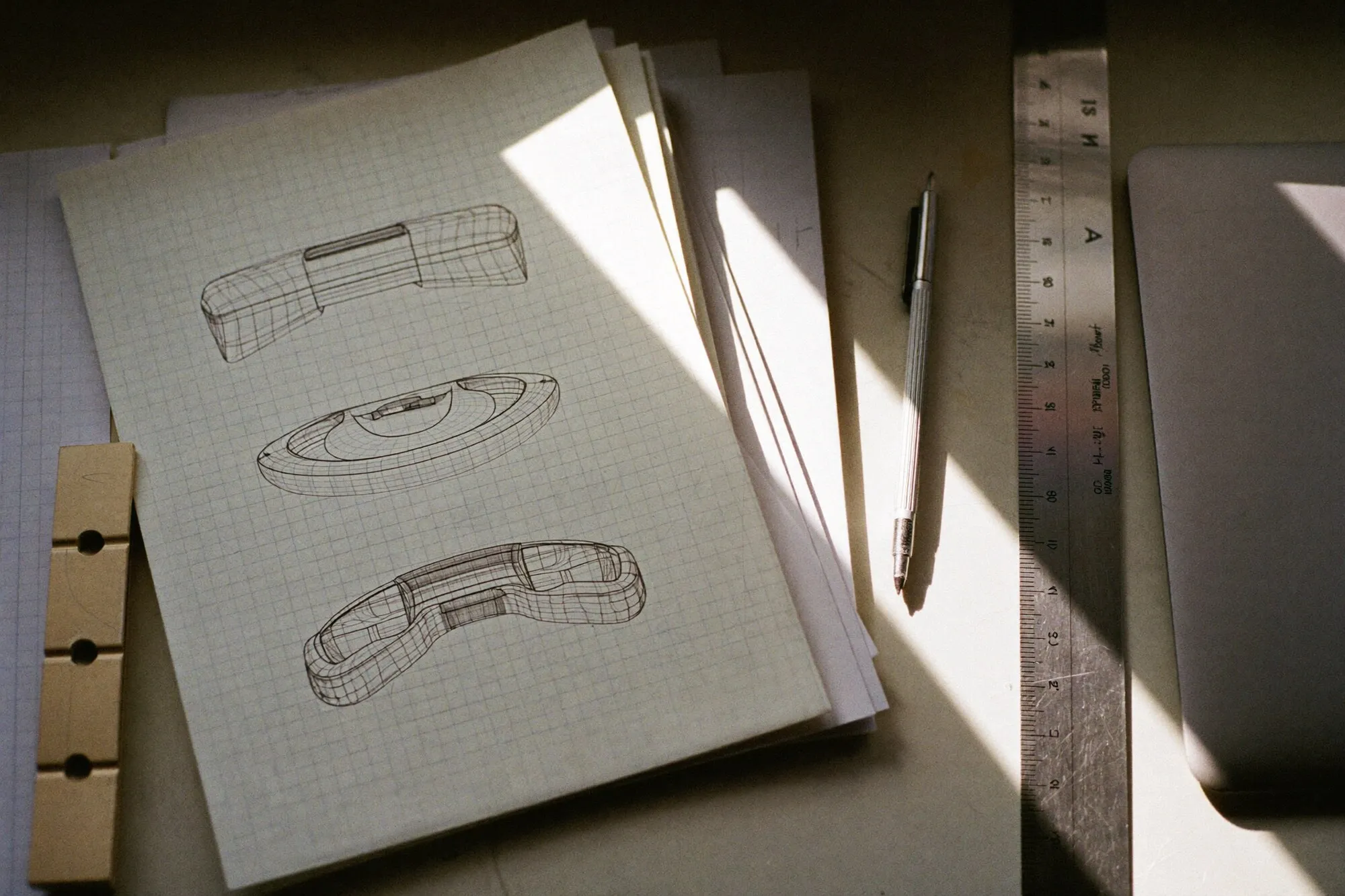 Schreibtisch von oben mit Rasterpapier und Skizzen im Morgenlicht