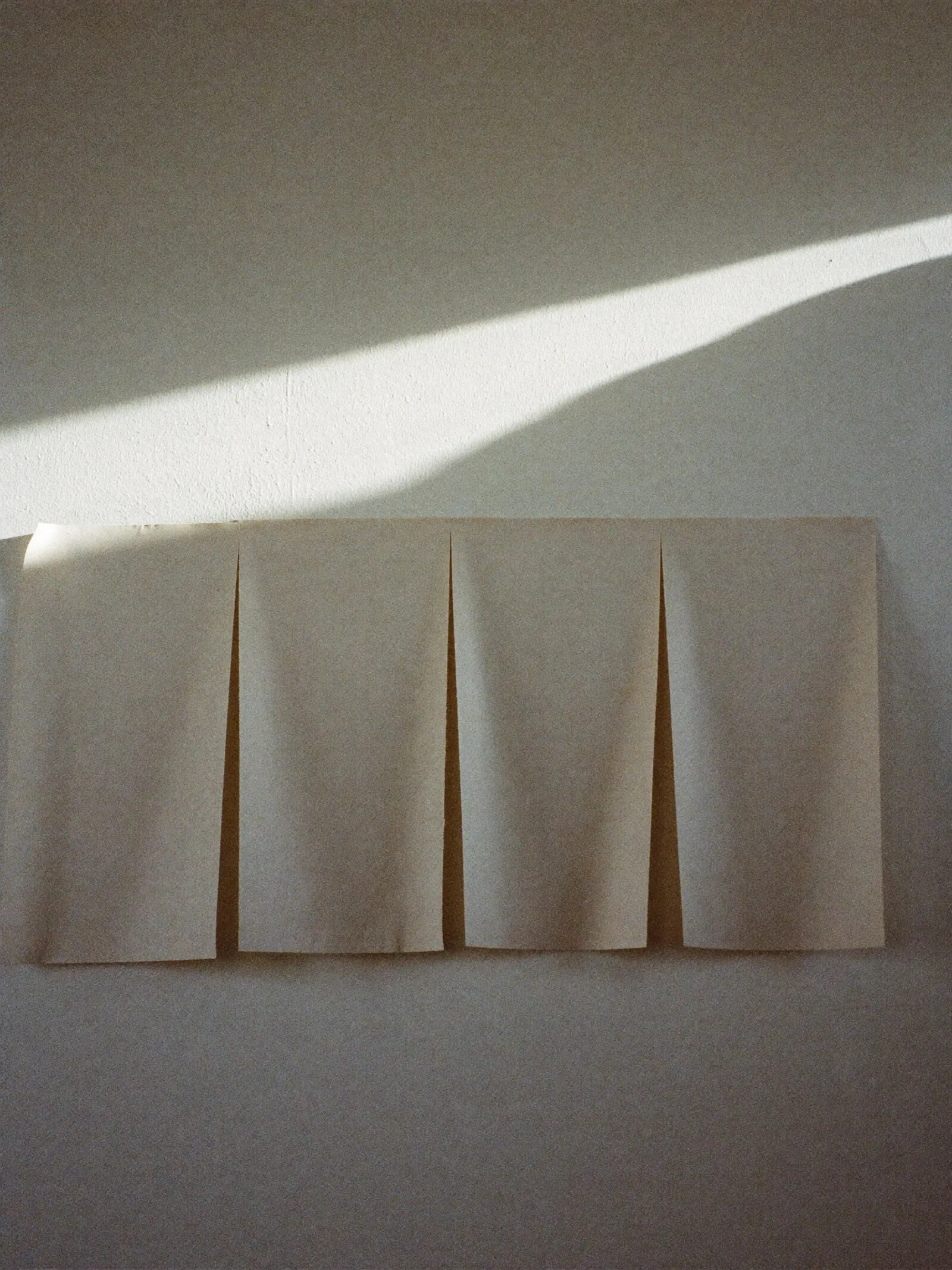 Leere Papierbögen in einer Reihe an einer Putzwand